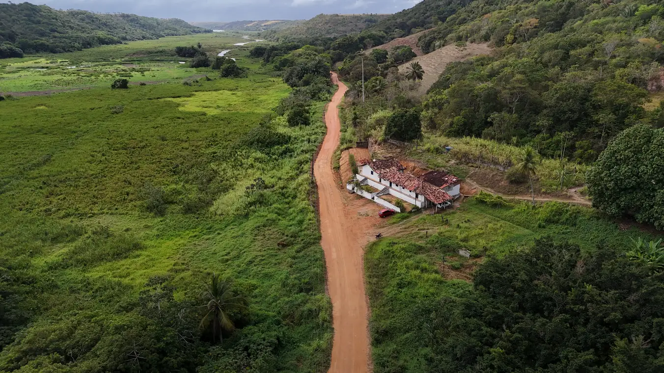 Trecho do Acesso Jequiá passando por uma casa de fazenda, visto do alto