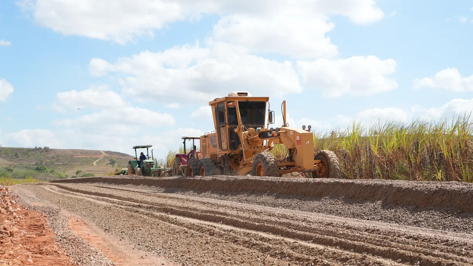 Motoniveladora e tratores preparando a base da estrada do Acesso Onça