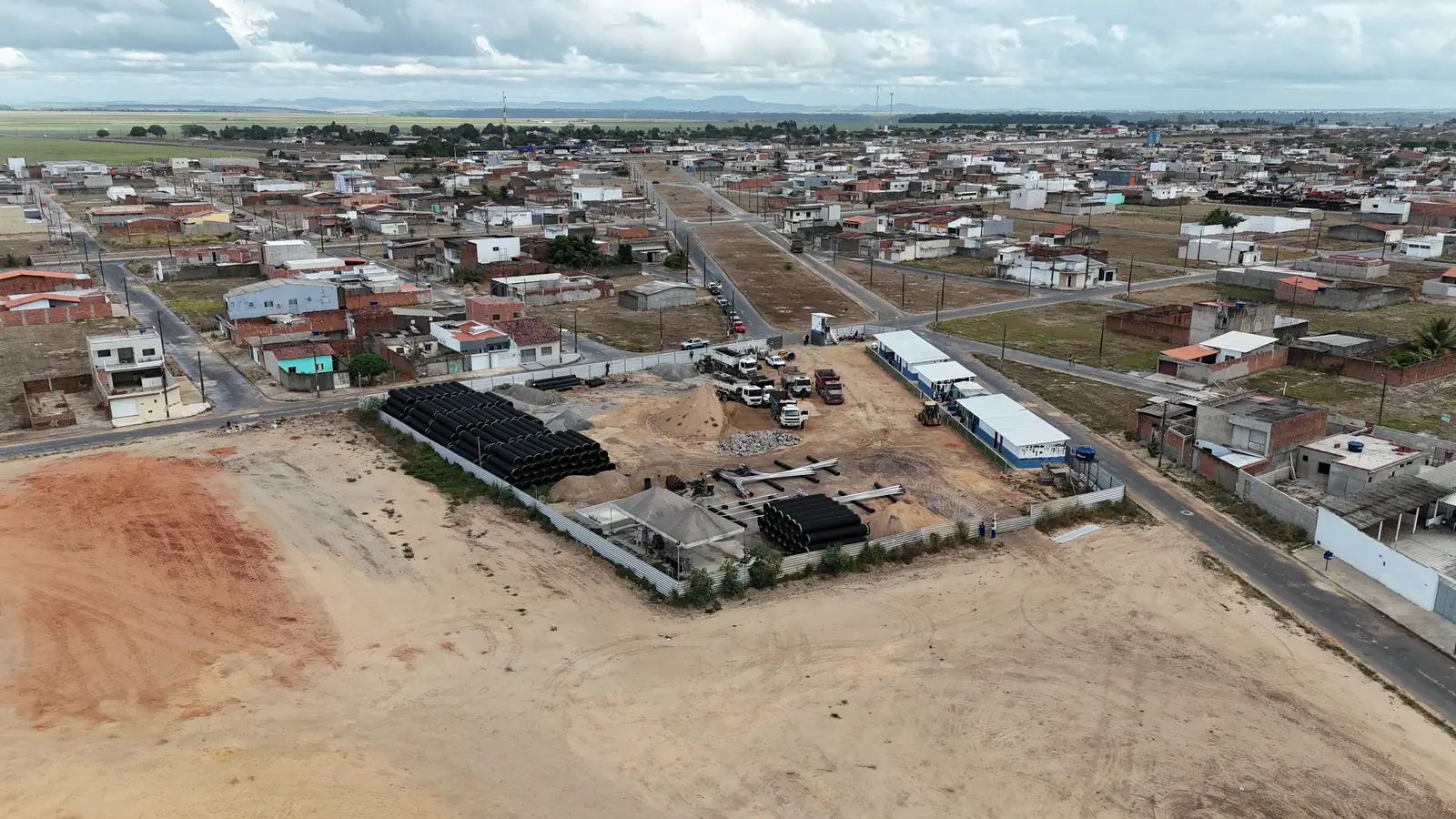 Vista aérea de terreno em obras na Avenida do Futuro, com o bairro ao fundo