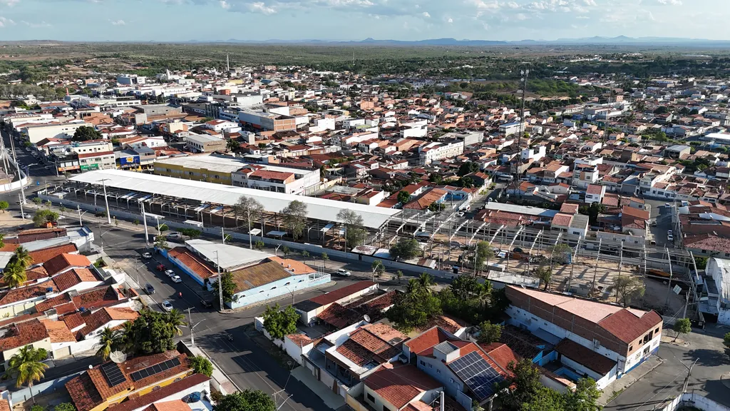 Cobertura da feira livre entre os telhados de Delmiro Gouveia, vista de longe