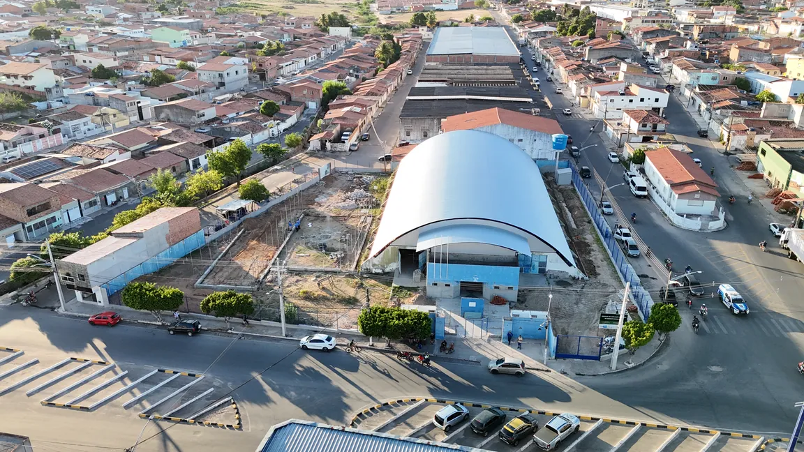 Vista aérea da quadra coberta com a praça e a rua em frente